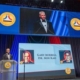 aviation-safety-hall-of-fame-garmin-induction-ceremony-with-presentation-screen-in-background-and-speaker-on-stage